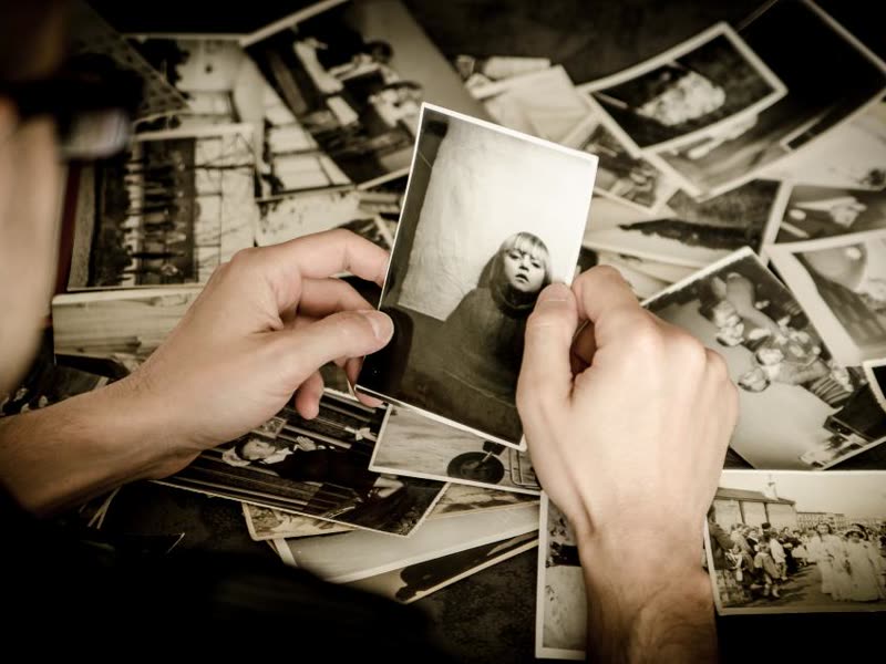 Hands sorting through a pile of black and white prints