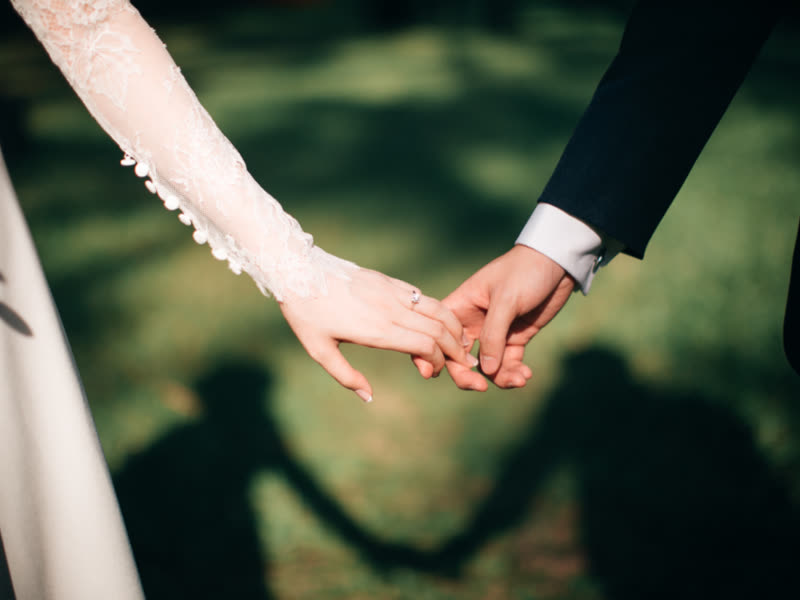 Two hands held together, casting a shadow on grass